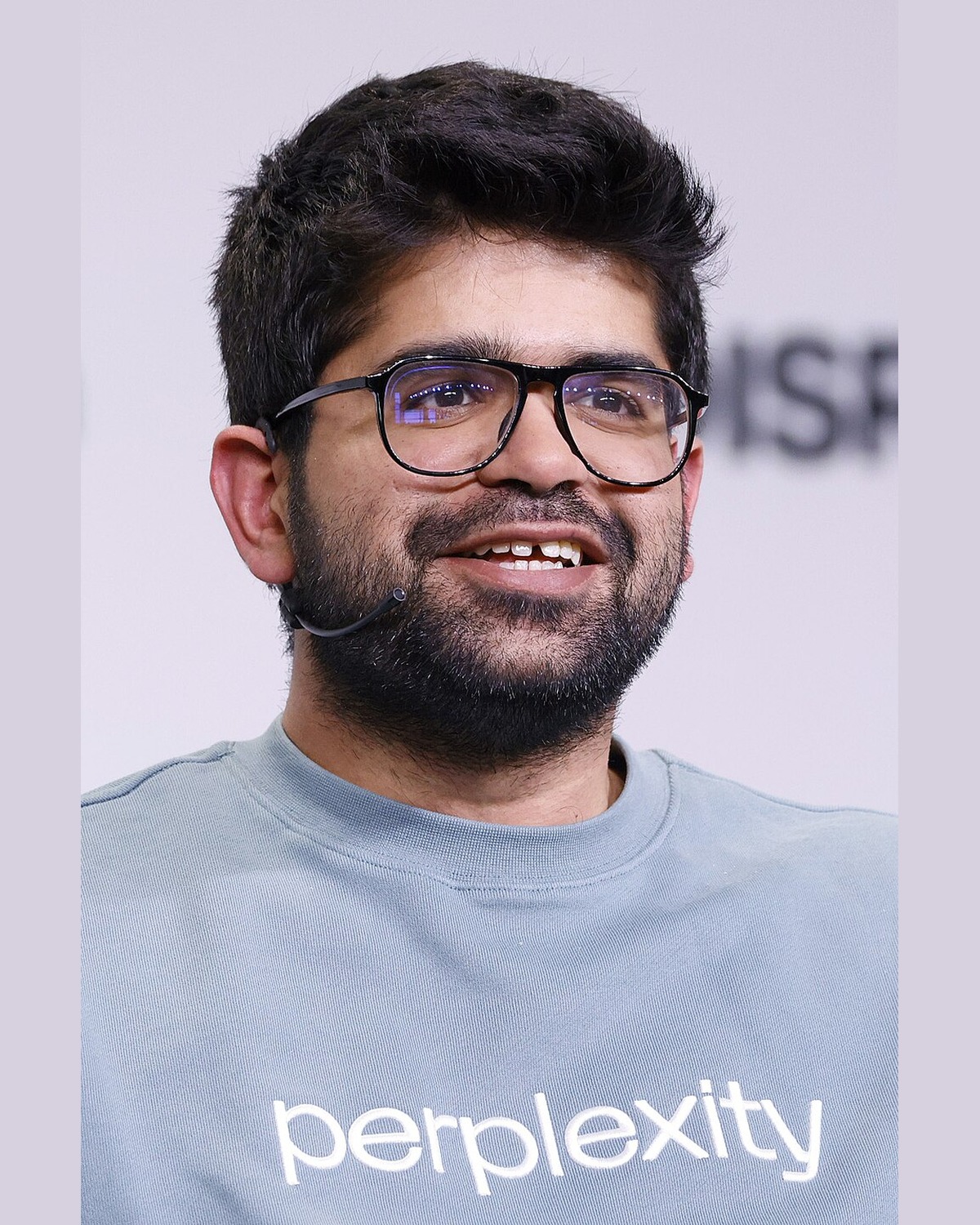 Aravind Srinivas, co-founder and CEO of Perplexity, wearing a Perplexity sweatshirt on stage